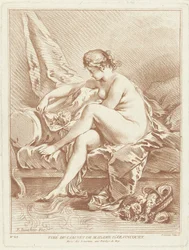 Nackte Frau, die auf einem Bett mit Blumen sitzt