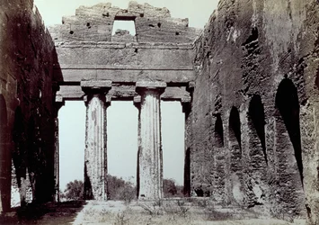Innenraum des Tempels der Concordia im Tal der Tempel in Agrigent. Im Vordergrund zwei dorische Säulen; an den Seiten eine gewölbte Umfassungsmauer