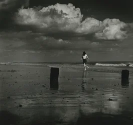 Kind spielt mit den Wellen am Strand