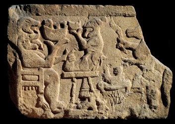 Iberische Kunst: Flachrelief, das eine mythologische Bankettszene darstellt, bei der ein Gott der Unterwelt zwei Köpfe mit offenem Mund vor einem Opferaltar hat. Um 500 v. Chr. aus dem Grab von Pozo Moro, Spanien. Madrid, Museo Arqueológico Nacional