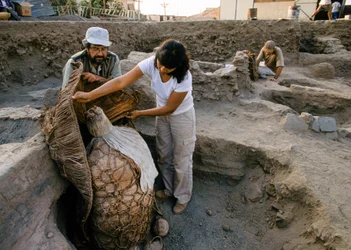 Archäologen mit einem Mumienbündel, gefunden an der Schulausgrabungsstätte, 2001