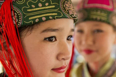 Porträt eines jungen Mädchens in Deel, mongolischer traditioneller Kleidung, beim Naadam, 2013 (Foto)