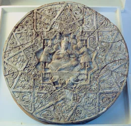 Sonnenscheibe, die einen König zeigt, der mit gekreuzten Beinen auf einem Thron sitzt, flankiert von zwei Engeln in der Mitte, gefunden in Ray, Iran