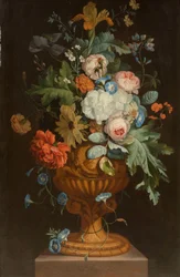 Blumen in einer Terrakottavase auf einem Sockel