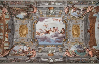 Hochzeitsbankett. Auf den Wolken sitzen Bacchus, Ariadne und Venus mit einer Figur, die Wein einschenkt, an einem runden Tisch. Die anderen Götter schauen von weitem zu.