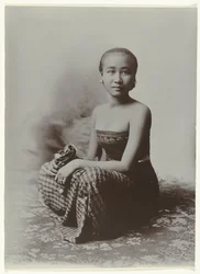Studio-Porträt einer sitzenden jungen javanischen Frau in einem Sarong mit Batik-Muster