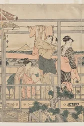 Frauen hängen Wäsche auf einem Balkon auf