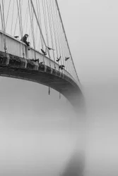 Mann auf nebliger Brücke