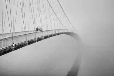 Menschen auf einer nebligen Brücke