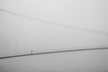 Einsamer Spaziergang auf nebliger Brücke