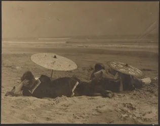 Strandszene mit Papierregenschirmen
