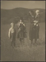 Frau und drei Kinder auf dem Feld
