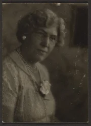 Frau mit weißer Blume und Perlen