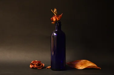 Getrocknete Rose und blaue Flasche