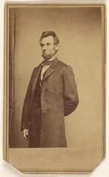 [Abraham Lincoln steht mit einem Arm hinter dem Rücken]