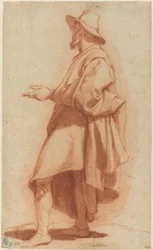 Stehender Mann mit Umhang und Hut