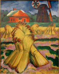 Kornhocken vor rotem Haus und Windmühle