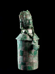Zylindrische Vase mit Jadeit-Mosaik, der Deckel ist ein Männerkopf mit Federkopfschmuck. Aus Tikal, ca. 250 bis 900