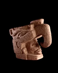 Präkolumbische Kunst, Maya-Zivilisation, präklassische Periode: Steinskulptur mit dem Kopf eines Mannes, der aus dem Maul eines zoomorphen, dem Himmelsvogel ähnelnden Gottes emporsteigt. 38 x 46 cm. Guatemala, Museo Nacional de Arqueología y Etnología