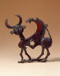 Orientalische Altertümer: Bronzekieferplatte, die ein androzephales Monster zeigt, das eine Hirschkuh zertrampelt. Aus Luristan, 750 v. Chr.
