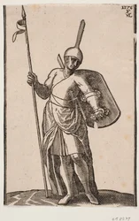 Stehender Soldat, frontal gesehen; Kopfbedeckung mit hohem, dünnem Top; in der rechten Hand ein Speer, auf dem linken Arm ein Schild, der von innen zu sehen ist