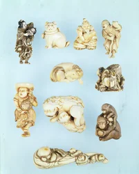 Auswahl an Netsuke: Ikkuha Sennin trägt die Hure von Benares; sitzender Welpe; Abe no Yasuneri hält ein Baby; Gamma Sennin; liegendes Pferd; Krieger zähmt einen entlaufenen Ochsen; stehender Holländer hält einen Hahn mit langem Schwanz; sitzender Affe hält