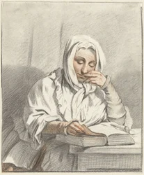 Lesende junge Frau an einem Tisch