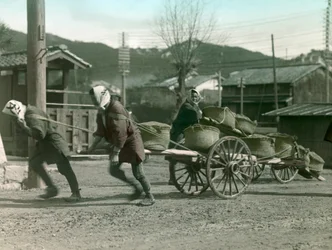 Japanische Bauern ziehen Reissäcke auf einem Karren, um 1900 - 1915
