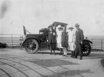Eine Gruppe von Menschen vor ihrem Auto am Meer, um 1920er Jahre
