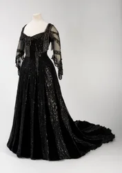 Schwarzes Abendkleid in voller Länge, getragen von Königin Alexandra, mit Perlen- und Paillettenverzierung und der charakteristischen schwarzen Seiden- und goldbeschrifteten Namensband von Königin Alexandra, hergestellt von Barolet of Knightsbridge, London