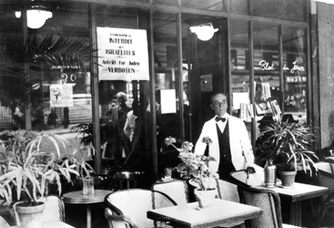 Hinweis in einem Restaurantfenster, der Juden den Eintritt verbietet, deutsch besetztes Paris, Juli 1940