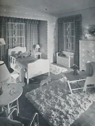 Kinderzimmer von W. & J. Sloane mit cremefarbenen Möbeln und zotteligen weißen Teppichen auf einem blau gestrichenen Boden