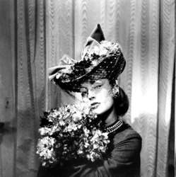 Frau mit Hut und Schleier, die einen Blumenstrauß hält, Paris, 1943