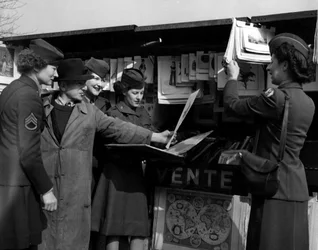 Zweiter Weltkrieg: Vier WACs der US-Armee diskutieren mit einem Buchhändler am Ufer der Seine (März 1945)
