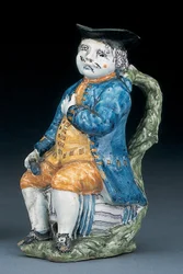 Toby-Krug mit blassem manganfarbenem Gesicht und Händen, hält einen leeren kugelförmigen bufffarbenen Krug in gewaschener blauer Jacke und Hose und grünem Wams, ca. 1800