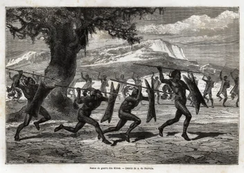 Die Obbos (Stamm aus Uganda) führen einen Kriegstanz auf. Gravur zur Illustration der Reise zum Albertsee, 1861-1864, von Sir Samuel White Baker, in „Le tour du monde, nouveau journal des voyages“ veröffentlicht unter der Leitung von Edouard Charton