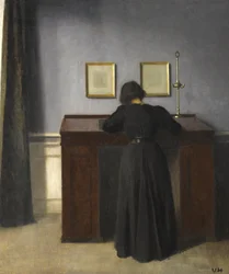 Ida steht an einem Schreibtisch, 1900