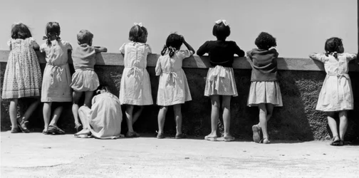Gruppe von Kindern, die sich gegen ein Geländer lehnen, Italien, ca. 1960