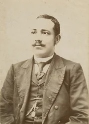 Fotografie eines Mannes in einem dunklen Anzug mit einer Taschenuhr in der Weste, 1886-1900