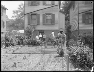 Eine Familie posiert neben ihrem Gemüsegarten im Hinterhof, Inwood, New York, ca. 1910