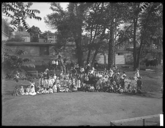 Große Gruppe von Kindern für ein Gruppenporträt auf einem unbekannten Spielplatz, ca. 1910