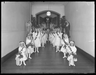 Kleine Mädchen im römisch-katholischen Waisenhaus, Kingsbridge, Bronx, kommen in weißen Kleidern mit Kränzen und Girlanden von der Kapelle zurück, 20. Oktober 1914