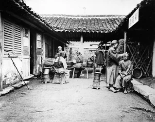 Wandernde Friseure in einem Landhaus, China, ca. 1875